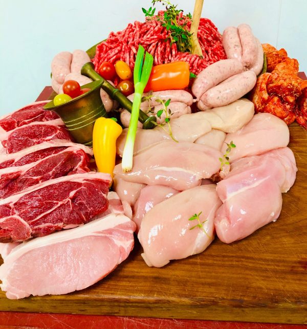 Assortment of fresh meats garnished with fresh herbs, spring onion and whole yellow pepper