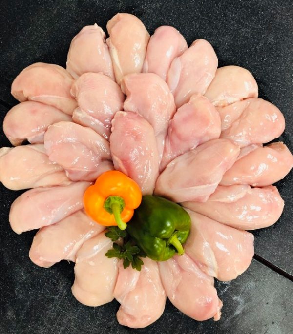 Circular display of fresh chicken breast fillets garnished with two whole peppers